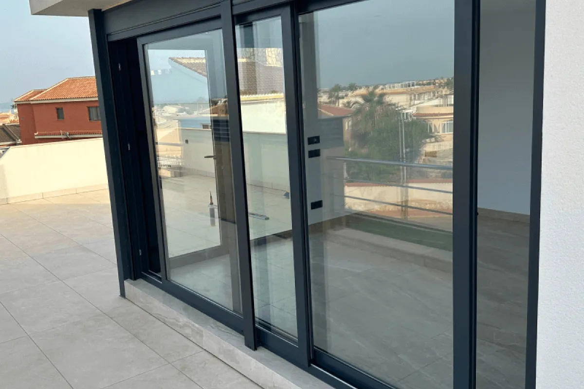 Anthracite aluminium sliding door on a penthouse terrace (Valencia)